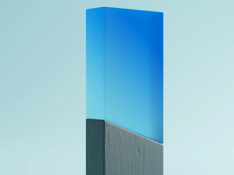 A blue acrylic block award on a grey base against a pale sky