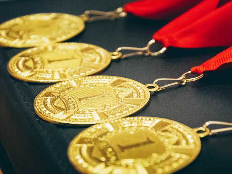 A row of gold medals with red ribbons